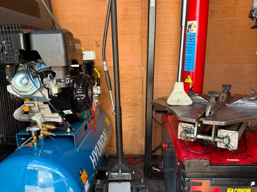 Mobile tyre fitting equipment set up in the 711 Breakdown Recovery van — tyre changer, compressor and jack