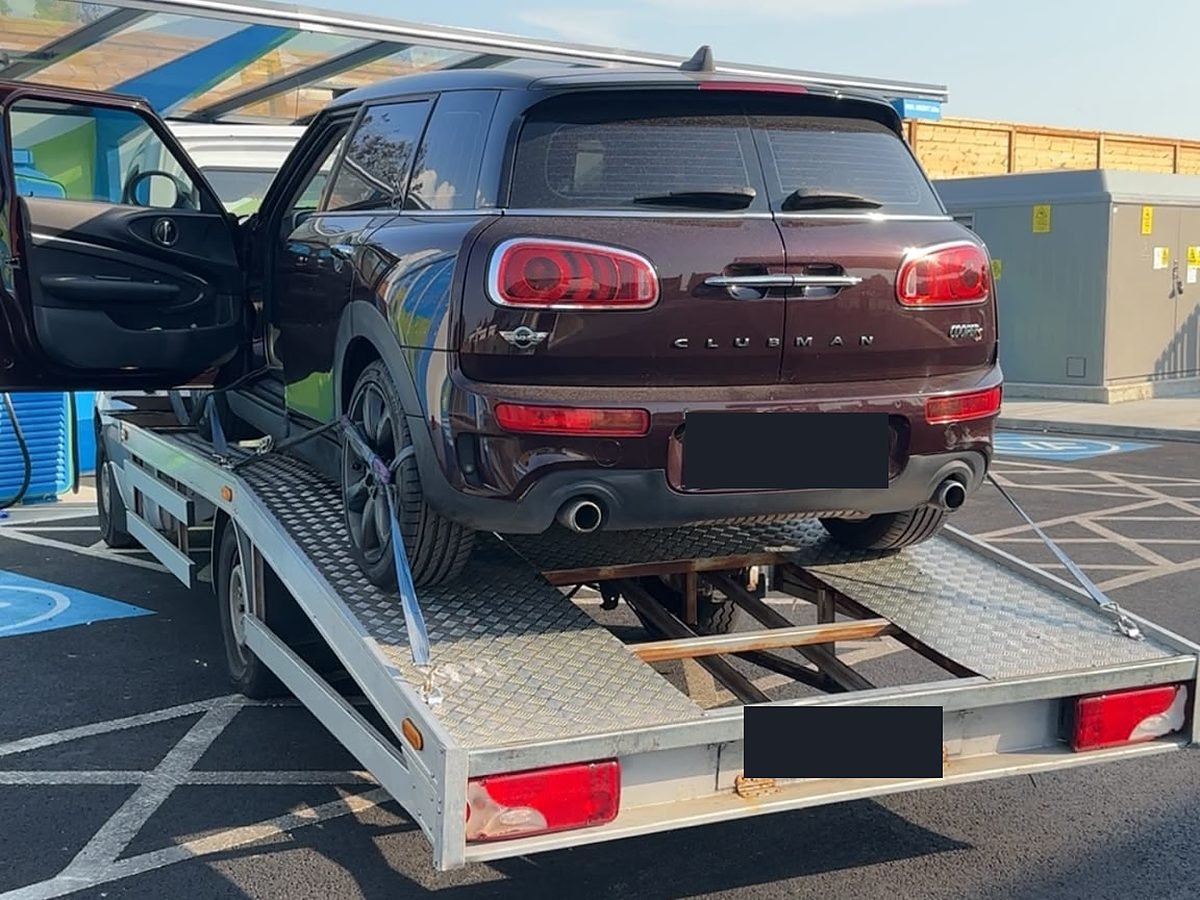 Mini Clubman car strapped onto a recovery trailer for transport