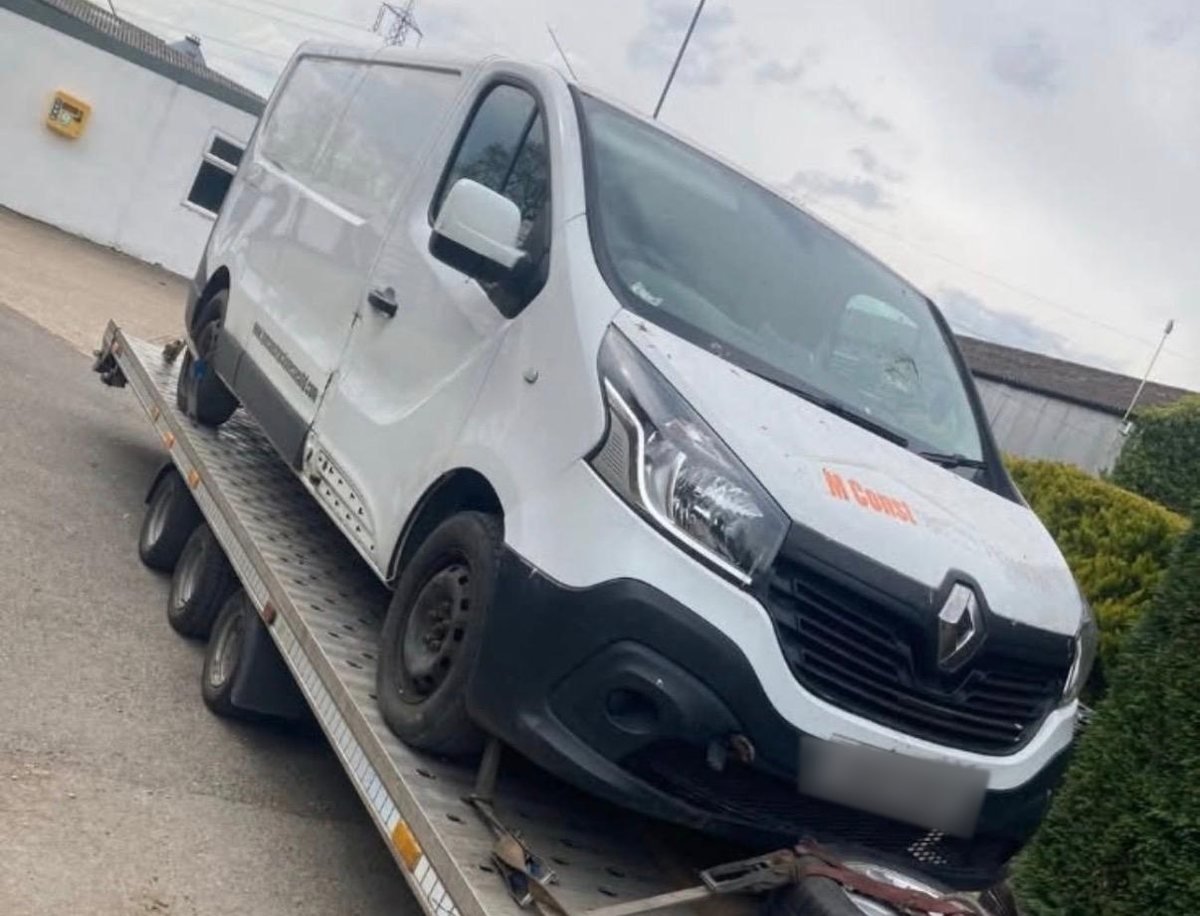White van loaded on a flatbed recovery trailer