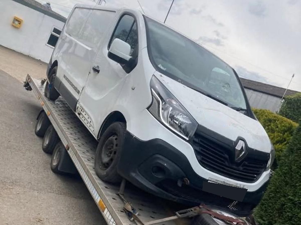 White Renault Trafic van loaded on a recovery trailer